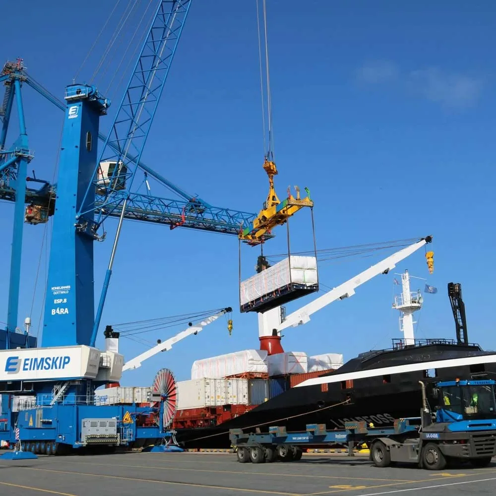 Mobile harbour crane loading cargo between a terminal and vessel