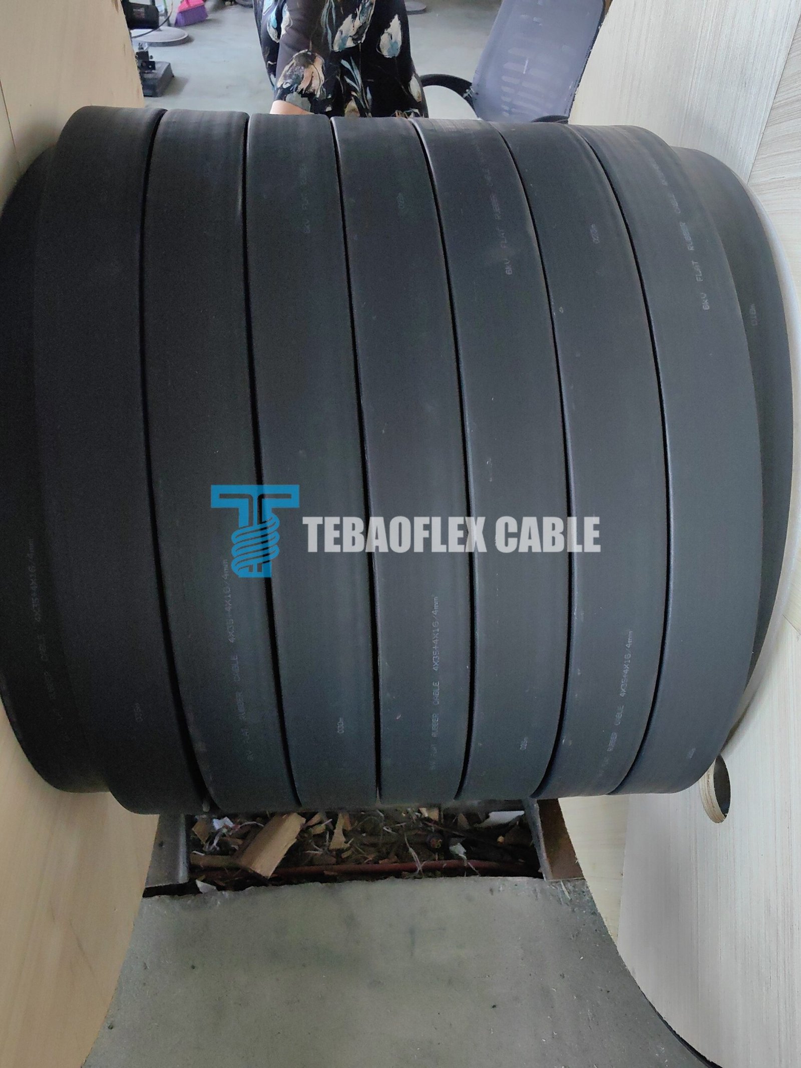 Black flat rubber cable sample wound in compact loops in a workshop