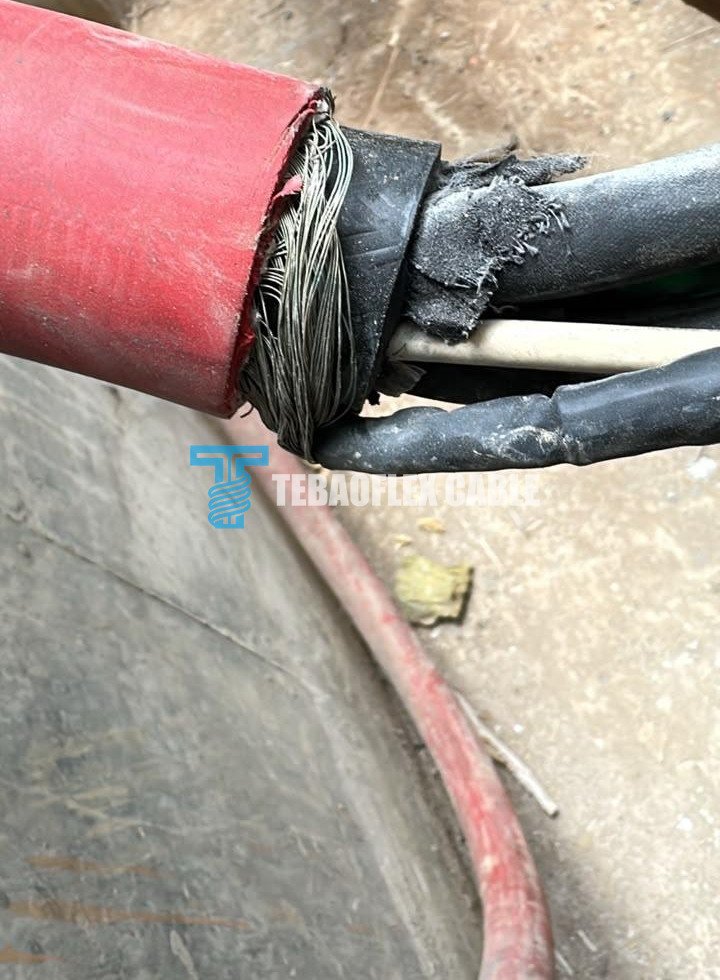 Opened red pump cable showing the metallic screen and internal elements of the existing cable