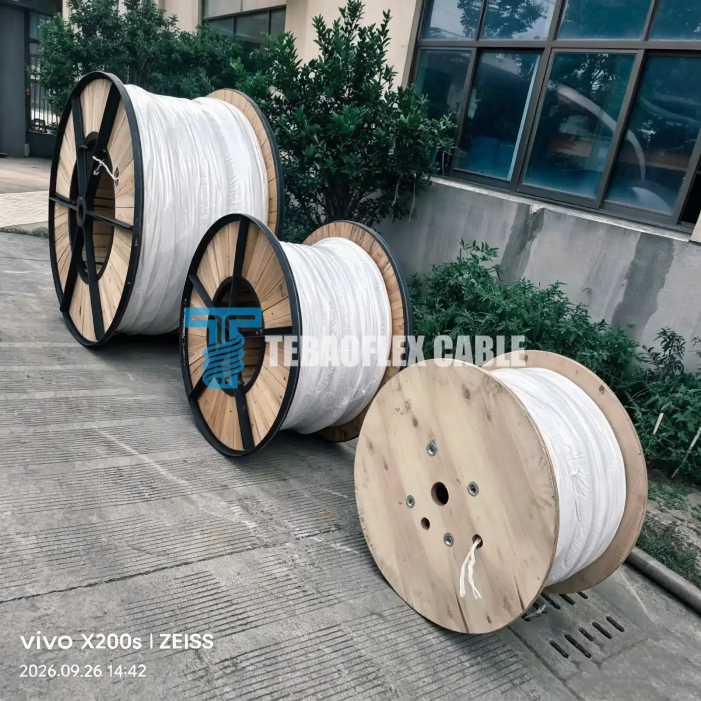 Three moisture-wrapped wooden export cable drums staged at TEBAOFLEX factory yard before timber lagging